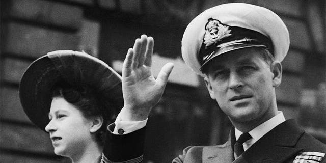 In this June 8, 1948, file photo, the Duke of Edinburgh, seated beside Princess Elizabeth, acknowledges the cheers of the crowd as the open Landau passes through Fleet Street on way to the Guildhall in London. (AP Photo/File)