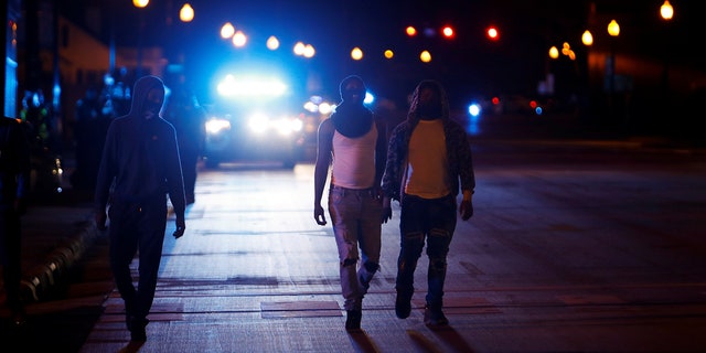 Protesters walk away from police vehicles as a few demonstrators ignore the dawn to dusk curfew following the killing of Andrew Brown Jr. by sheriffs last week, in Elizabeth City, North Carolina, U.S. April 27, 2021. REUTERS/Jonathan Drake