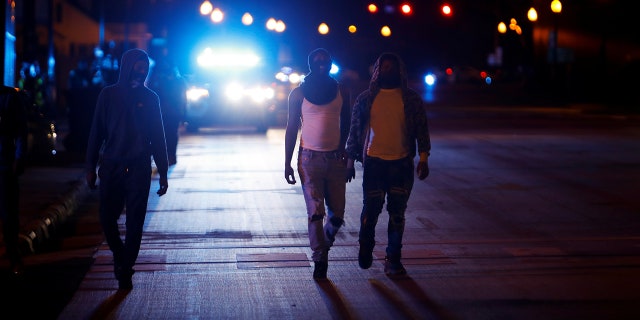 Protesters walk away from police vehicles as a few demonstrators ignore the dawn to dusk curfew following the killing of Andrew Brown Jr. by sheriffs last week, in Elizabeth City, North Carolina, U.S. April 27, 2021. REUTERS/Jonathan Drake