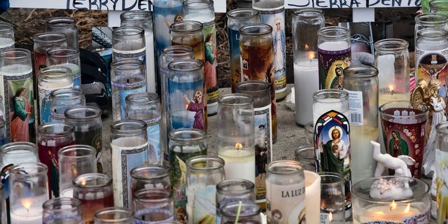 Candles and crosses are placed as a memorial for three children who were killed at the Royal Villa apartments complex in the Reseda section of Los Angeles. 