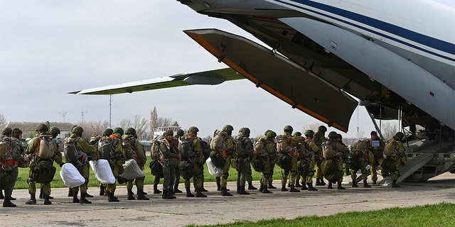 Russian paratroopers load into a plane for airborne drills during maneuvers in Taganrog, Russia, Thursday, April 22, 2021. Russia's defense minister on Thursday ordered troops back to their permanent bases following massive drills amid tensions with Ukraine.