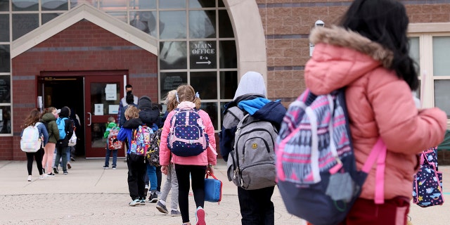 Girls and boys head into the Beebe School, in Malden, Massachusetts, on April 5, 2021, as they return to full-time in-person school. 