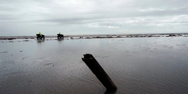 Lafourche Parish deputies patrol along the shoreline of the Gulf of Mexico, not far from where a lift boat capsized during a storm on Tuesday, killing one with 12 others still missing, on Elmer's Island, La., Thursday, April 15, 2021. (AP Photo/Gerald Herbert)