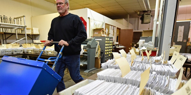This Tuesday, Nov. 3, 2020 file photo shows Board of Elections worker Bob Moody moving boxes of ballots at the Trumbull County Board of Elections in Warren, Ohio.