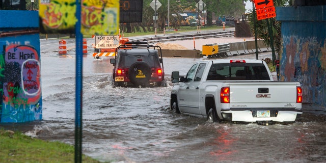 Trucks make their way through high water Saturday, April 10, 2021, at the Graffiti Bridge in Pensacola after a powerful storm swept through the area.Saturday Storm 1