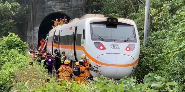 Rescue workers gather near one end of the train involved in a derailment. (AP/Executive Yuan)