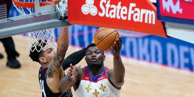 New Orleans Pelicans forward Zion Williamson (1) goes to the basket against Philadelphia 76ers forward Danny Green in the second half of an NBA basketball game in New Orleans, Friday, April 9, 2021.