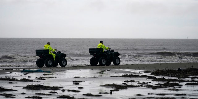 Lafourche Parish deputies patrol along the shoreline of the Gulf of Mexico, not far from where a lift boat capsized during a storm on Tuesday, killing one with 12 others still missing, on Elmer's Island, La., Thursday, April 15, 2021. (AP Photo/Gerald Herbert)