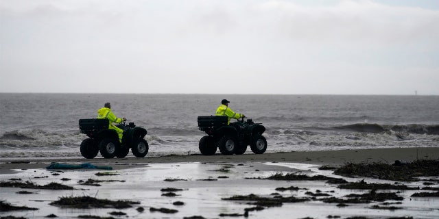 Lafourche Parish deputies patrol along the shoreline of the Gulf of Mexico, not far from where a lift boat capsized during a storm on Tuesday, killing one with 12 others still missing, on Elmer's Island, La., Thursday, April 15, 2021. (AP Photo/Gerald Herbert)