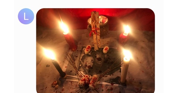 An altar that Larry Millete sent to a friend in September 2020, which appears to have blood splatter or red wax over an image of the couple. 