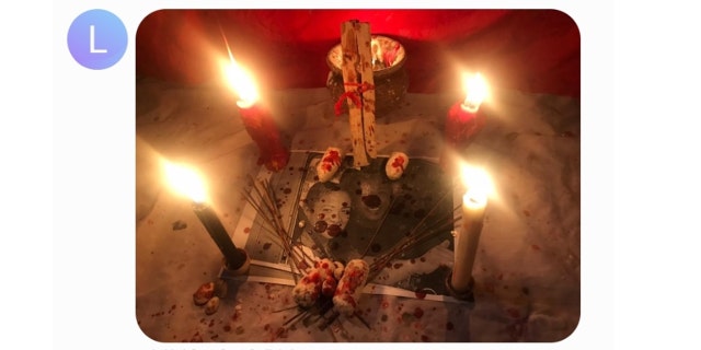 An altar that Larry Millete sent to a friend in September 2020, which appears to have blood splatter or red wax over an image of the couple. 