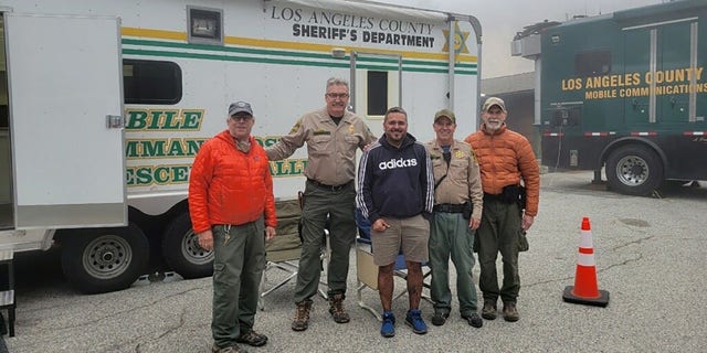 Compean, center, posed for a photo with his rescuers after he was found safe and airlifted off the mountain.