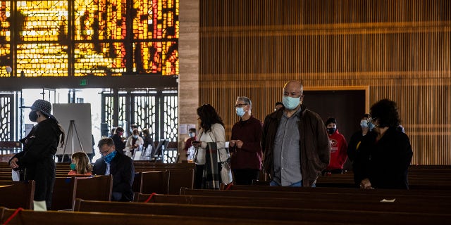 People are seen inside Cathedral of Saint Mary of the Assumption ahead of an in-church Easter Mass celebration in San Francisco, California Sunday, April 4, 2021.