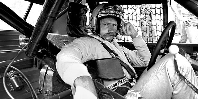 Dale Earnhardt Sr sits in his #2 Wrangler Pontiac Grand Prix while it is repaired after an accident during the 1981 Firecracker 400 in 1981.