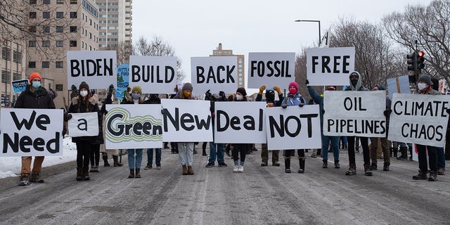 Activists hold signs calling for President Joe Biden to support a Green New Deal in St. Paul, MN on Jan. 29, 2021. 
