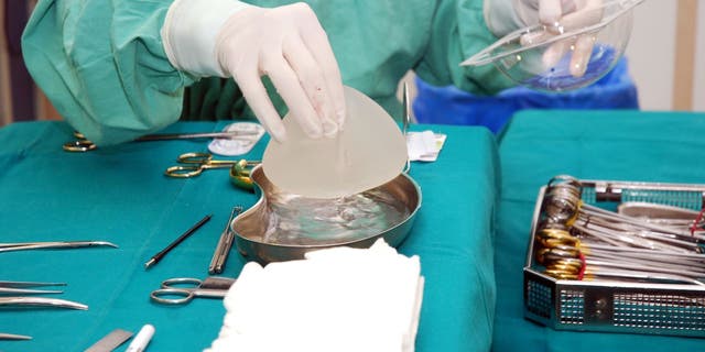 A nurse prepares an implant for surgery 