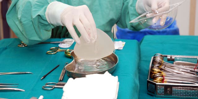 A nurse prepares an implant for surgery 