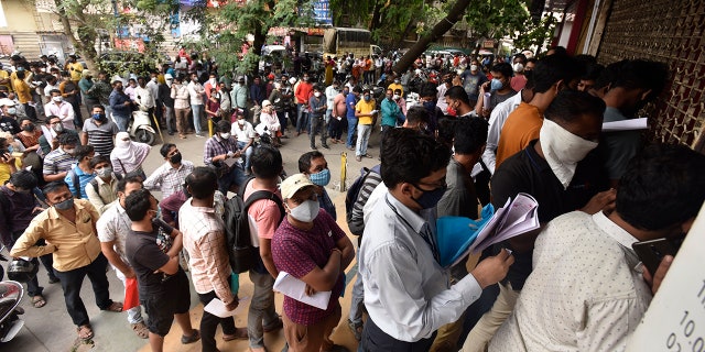 April 8, 2021: People wait in queues outside the office of the Chemists Association to demand necessary supply of the anti-viral drug Remdesivir, in Pune, India.