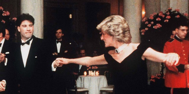 Diana, Princess Of Wales, wearing a midnight blue velvet, off the shoulder evening gown designed by Victor Edelstein, is watched by US President Ronald Reagan and First Lady Nancy Reagan, as she dances with John Travolta at the White House on November 9, 1985 in Washington, DC. 