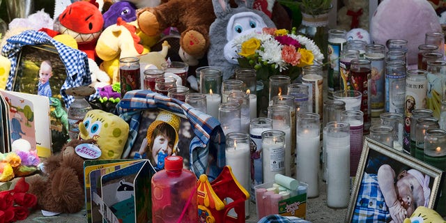 Des photos, des bougies, des fleurs et des ballons sont placés en mémoire de trois enfants tués dans le complexe d'appartements Royal Villa dans la section Reseda de Los Angeles, le lundi 12 avril 2021 (Crédit: AP Photo / Richard Vogel)