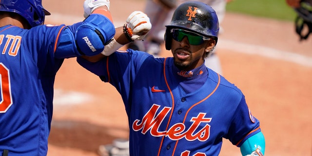 New York Mets' Francisco Lindor (12) is congratulated by Michael Conforto after scoring on a solo home run during the fifth inning of a spring training baseball game Miami Marlins, Tuesday, March 23, 2021, in Port St. Lucie, Fla. (AP Photo/Lynne Sladky)