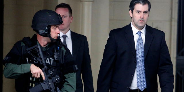 FILE- In this Dec. 5, 2016 file photo, Michael Slager, at right, walks from the Charleston County Courthouse under the protection from the Charleston County Sheriff's Department after a mistrial was declared for his trial in Charleston, S.C. (AP Photo/Mic Smith, File)