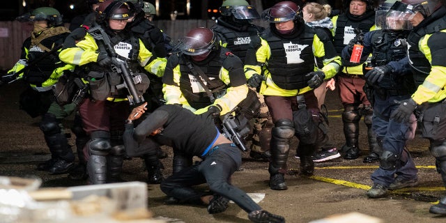 A demonstrator is arrested by police for violating curfew and an order to disperse during a protest against the police shooting of Daunte Wright, late Monday in Brooklyn Center, Minn. (AP)