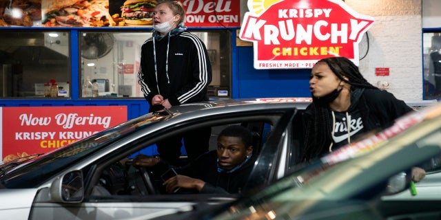 Drivers react as a line of police advances into a gas station in an effort to push back demonstrators gathered for a protest against the police shooting of Daunte Wright, late Monday, in Brooklyn Center, Minn. (AP)