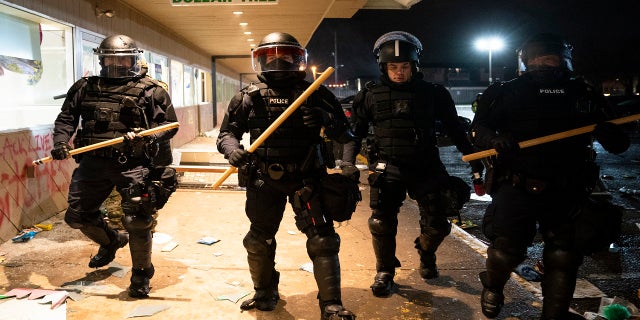 Police clear a strip mall of demonstrators after issuing orders to disperse late Monday in Brooklyn Center, Minn. (AP)