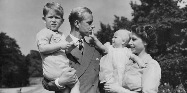 In this Aug. 1951 file photo, Britain's Queen Elizabeth II, then Princess Elizabeth, stands with her husband Prince Philip, the Duke of Edinburgh, and their children Prince Charles and Princess Anne at Clarence House, the royal couple's London residence. Prince Philip was born into the Greek royal family but spent almost all of his life as a pillar of the British one. His path was forged when he married the heir to the British throne, and a promising naval career was cut short when his wife suddenly became Queen Elizabeth II. Nevertheless, he set about forging a place for himself as royal consort. He was a patron of charities and a supporter of projects for young people. He was married for more than 73 years and was still carrying out royal engagements into his late 90s.