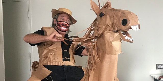 Marriott poses with his paper horse Russell, which he made out of an ironing board, a lamp and brown paper bags. (David Marriott via AP)