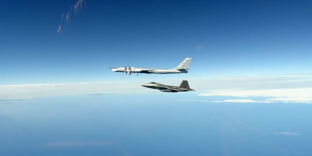 A North American Aerospace Defense Command F-22 Raptor flies next to a Russian Tu-95 bomber during an intercept in the Alaskan Air Defense Identification Zone June 16, 2020.