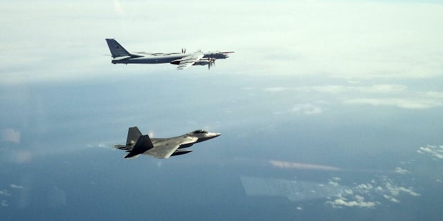 A North American Aerospace Defense Command F-22 Raptor flies next to a Russian Tu-95 bomber during an intercept in the Alaskan Air Defense Identification Zone June 16, 2020.