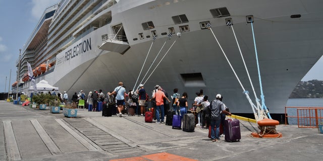 Des ressortissants britanniques, canadiens et américains font la queue aux côtés du navire de croisière Royal Caribbean Reflection pour être évacués gratuitement, à Kingstown, sur l'île de Saint-Vincent, dans les Caraïbes orientales, le vendredi 16 avril 2021 (Crédit: AP Photo / Orvil Samuel)
