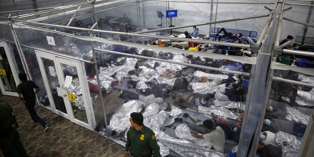 In this March 30, 2021, file photo, young minors lie inside a pod at the Donna Department of Homeland Security holding facility, the main detention center for unaccompanied children in the Rio Grande Valley run by U.S. Customs and Border Protection (CBP), in Donna, Texas. (AP Photo/Dario Lopez-Mills, Pool, File)