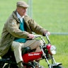 WINDSOR, ENGLAND - MAY 13: HRH The Duke of Edinburgh rides on his mini motorbike during the Royal Windsor Horse Show at Home Park, Windsor Castle on May 13, 2005 in Windsor, England. (Photo by Julian Finney/Getty Images)
