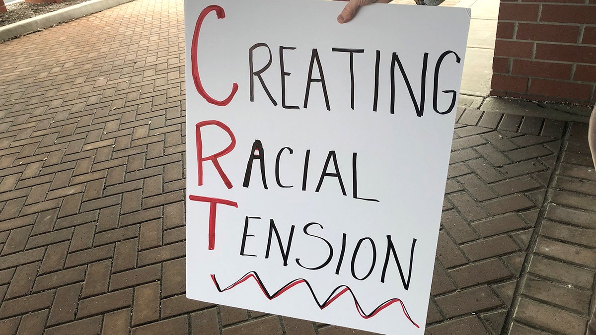 A protester holds a sign outside a building as the Noblesville school board meets inside on Tuesday, May 4, 2021. 