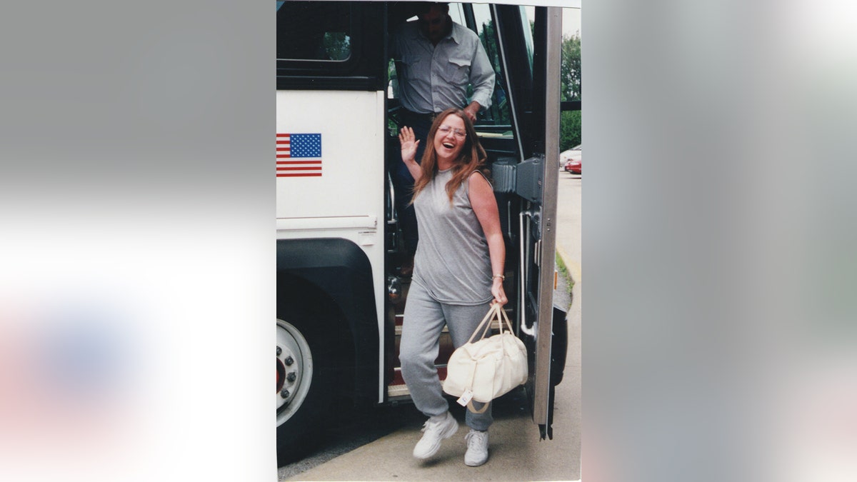 Lori Arnold steps off the bus as she returns home to Ottumwa, IA, from her first prison sentence in 1999.
