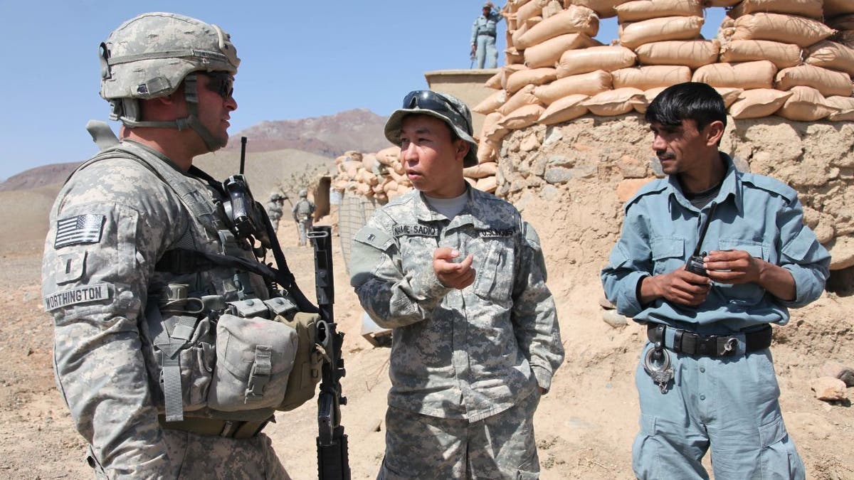U.S. Army 1st Lt. Paul Worthington (left) listens to an interpreter while speaking with an Afghan National Policeman about security issues during a visit to a National Police outpost in the Jabal Saraj district of the Parwan province of Afghanistan on Oct. 8, 2010.