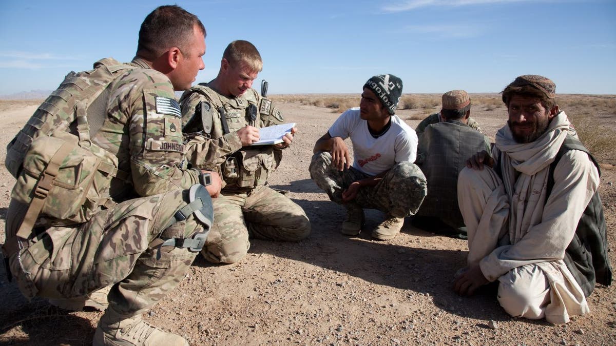 U.S. Army Staff Sgt. Nathaniel Johnson, U.S. Army Capt. James Nelson and Hader, interpreter, speak with elders in the Shorbak Desert, Kandahar Province, Afghanistan 9 Dec. 2011. (U.S. Army Photo by Spc. Phil Kernisan/Released)