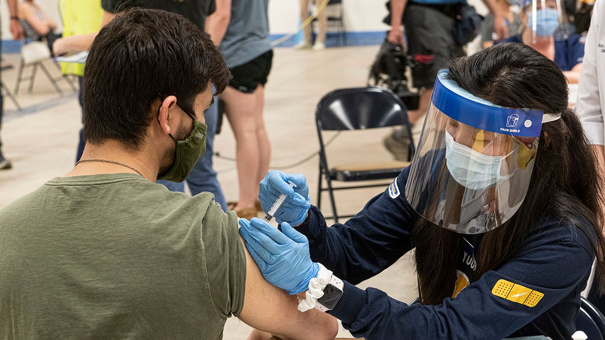 In this April 8, 2021, student Jarrett Woo gets his Johnson & Johnson COVID-19 vaccination from nursing student Allie Rodriguez. (AP Photo/Phil Long, File)