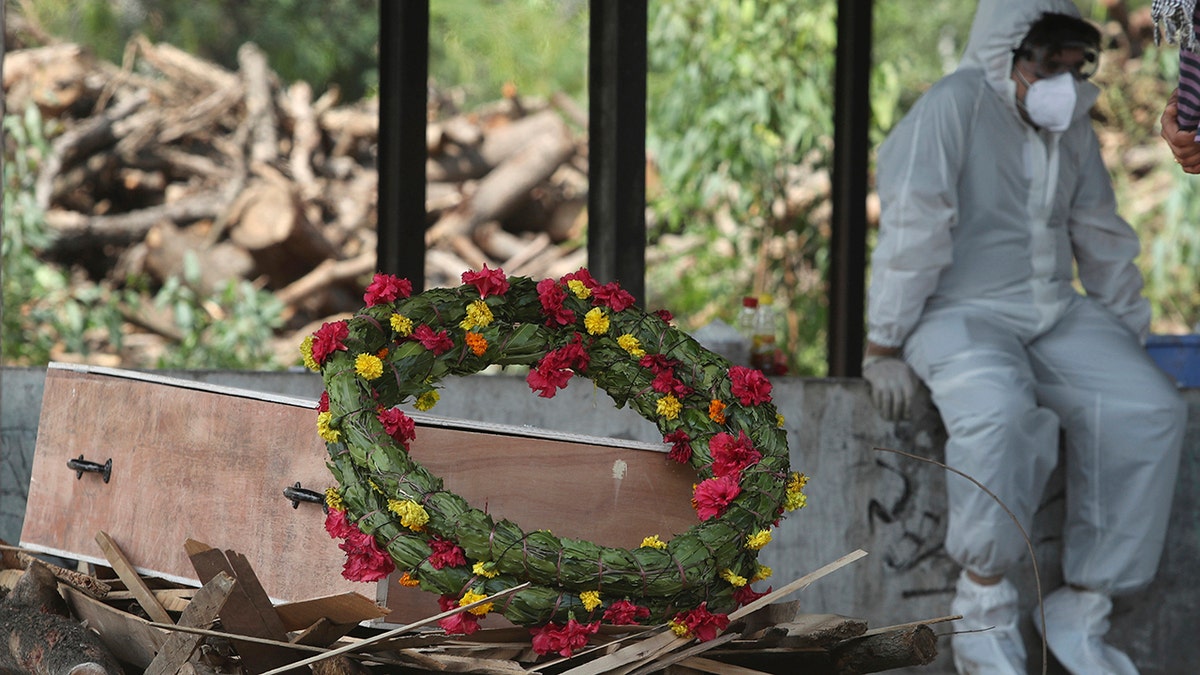 A wreath lies on the coffin of a COVID-19 victim before his cremation in Jammu, India, Friday, April 30, 2021. (Associated Press)