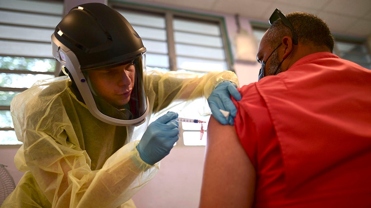 FILE - In this March 10, 2021 file photo, a healthcare worker injects a man with a dose of the Moderna COVID-19 vaccine during a mass vaccination campaign, at the Maria Simmons elementary school in Vieques, Puerto Rico. (AP Photo/Carlos Giusti, File)