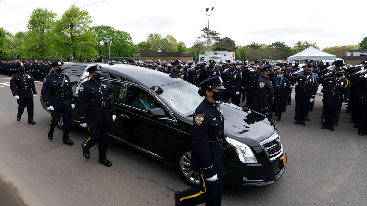 Thousands of police officers line the street as the hearse bearing New York police officer Anastasios Tsakos leaves the St. Paraskevi Greek Orthodox Shrine Church, Tuesday, May 4, 2021, in Greenlawn, N.Y.