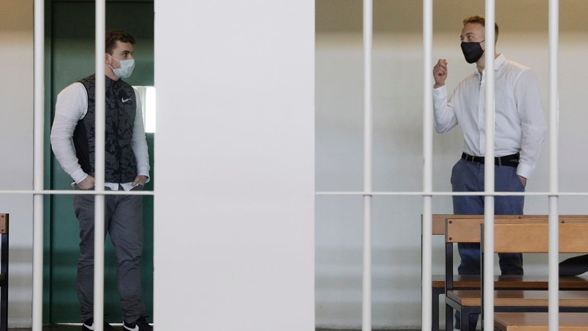 Gabriel Natale-Hjorth, right, talks to his co-defendant Finnegan Lee Elder, before a jury began deliberating their fate as they are on trial for the slaying of an Italian plainclothes police officer on a street near the hotel where they were staying while on vacation in Rome.  (AP Photo/Gregorio Borgia)