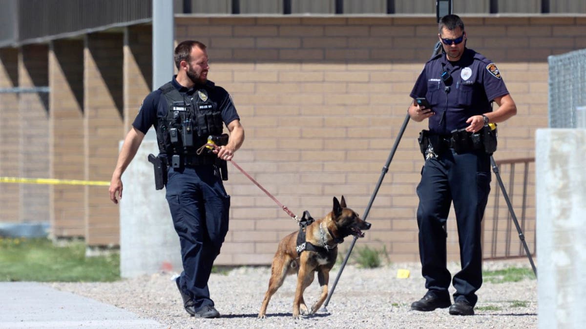 Police walk outside Rigby Middle School following a shooting there earlier Thursday, May 6, 2021, in Rigby, Idaho. Authorities said that two students and a custodian were injured, and one student has been taken into custody. (AP Photo/Natalie Behring)