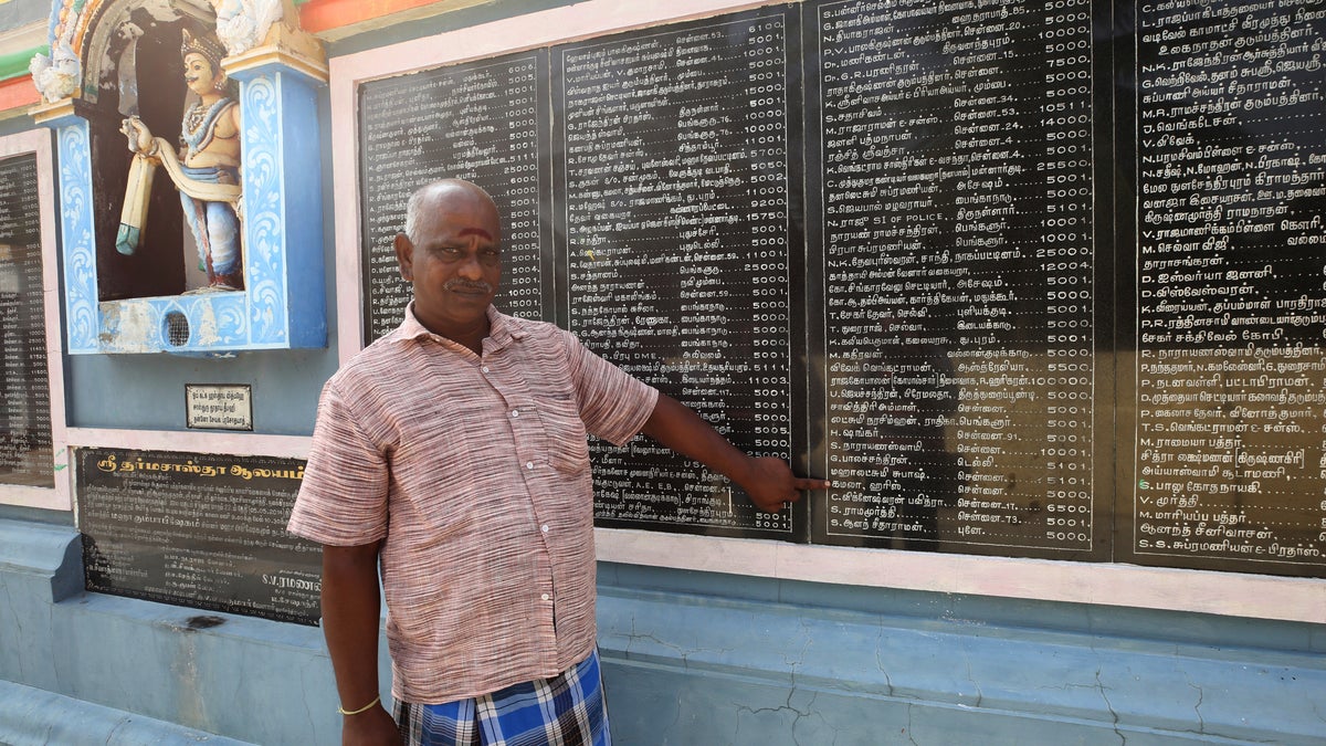 FILE - In this Nov. 3, 2020, file photo, a villager points out the name of Kamala Harris written in Tamil language and the amount she donated for the renovation of temple through her relative, in Thulasendrapuram village, south of Chennai, Tamil Nadu state, India. The lush green village is the hometown of Harris' maternal grandfather who migrated from there decades ago. (AP Photo/Aijaz Rahi, File)