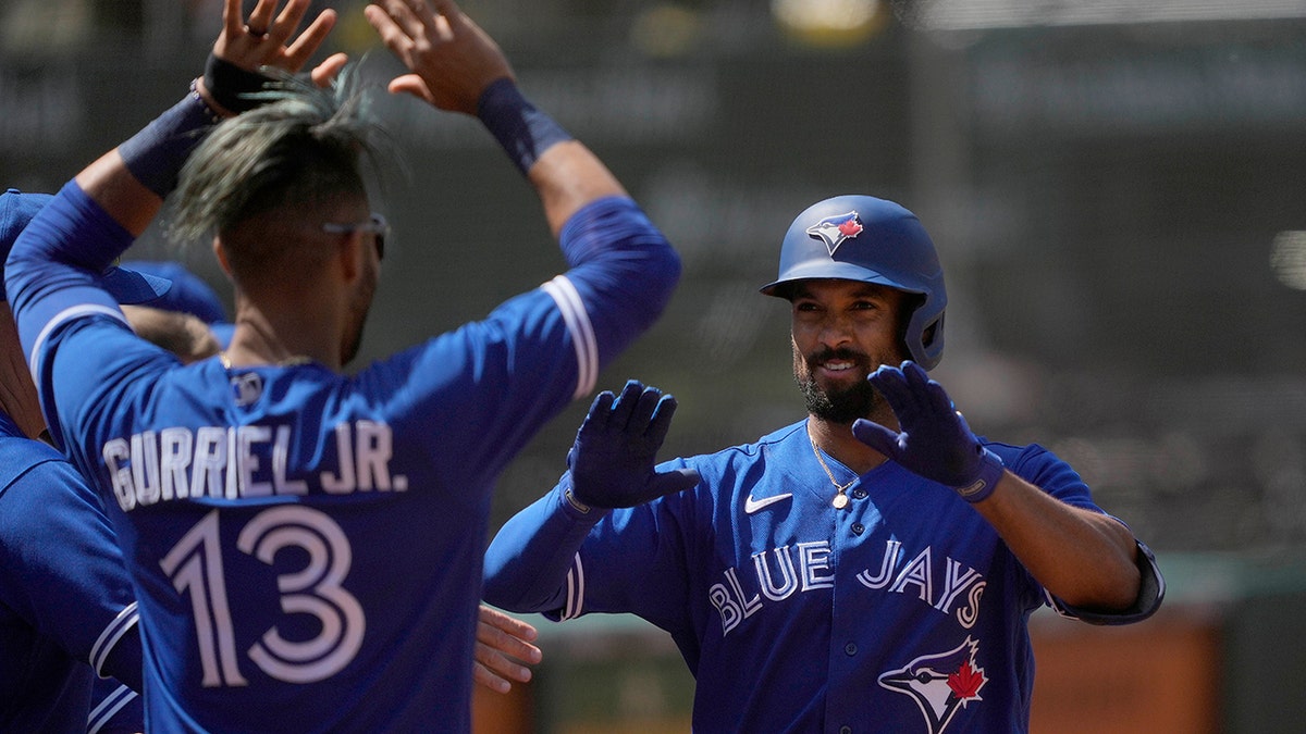 The Toronto Blue Jays' Marcus Semien, right, celebrates with Lourdes Gurriel Jr. (13) after hitting a solo home run against the Oakland Athletics May 6, 2021. (AP Photo/Tony Avelar)