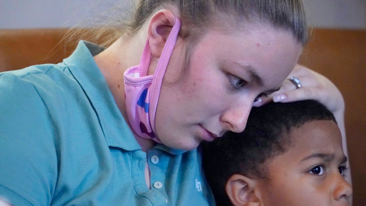 Alexis Rankin, hugs her oldest son, Peyton Lee, 5, as she recalls the events of the evening of February 8, 2018, when she and her on-again-off-again boyfriend Willie Jones Jr., argued while on their way to her stepfather's home in Scott County, Miss. Shortly after arriving, Jones, who is black, was discovered hanging from a tree in the yard of Rankin's family home. The sheriff's department and the Mississippi Bureau of Investigation, both ruled the death a suicide. However, a Jackson-area judge in April awarded close to $11.4 million to Jones' family in a civil suit claiming wrongful death, alleging that Rankin's stepfather, Harold O'Bryant, Jr., either killed Jones or failed to prevent him from killing himself. (AP Photo/Rogelio V. Solis)