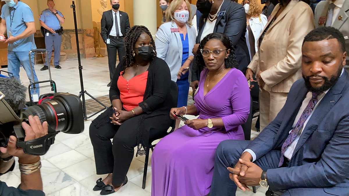 Relatives of Ahmaud Arbery, including sister Jasmine Arbery, left, and mother, Wanda Cooper Jones, second from left, sit at the Georgia state capitol in Atlanta on Monday, May 10, 2021. They witnessed Georgia Gov. Brian Kemp sign a law repealing citizen's arrest in Georgia, partly blamed for Ahmaud Arbery's fatal shooting death near Brunswick in 2020. (AP Photo/Jeff Amy)